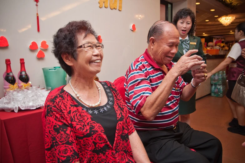 older man and woman using an electronic device