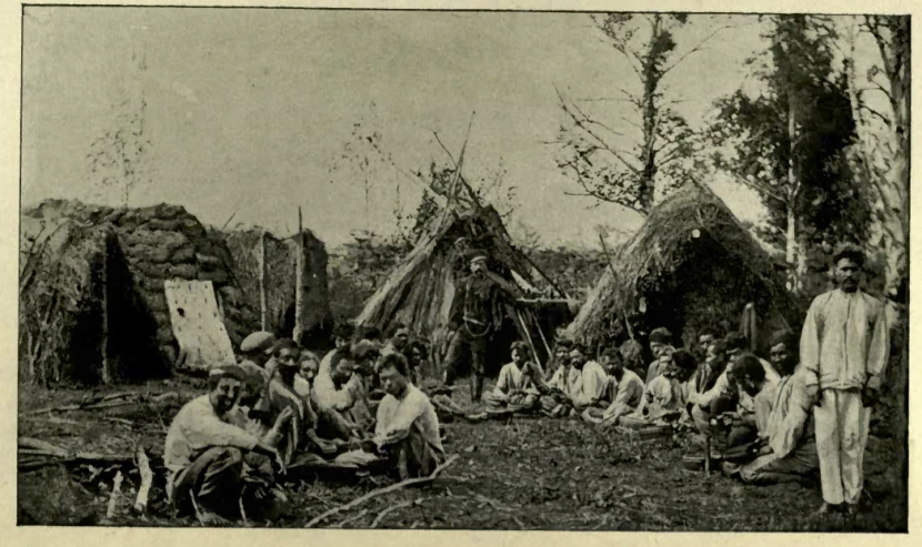 a group of indian women sitting next to a wooden structure