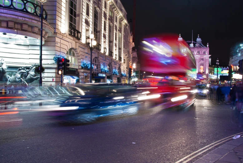 people and cars driving down the road at night time