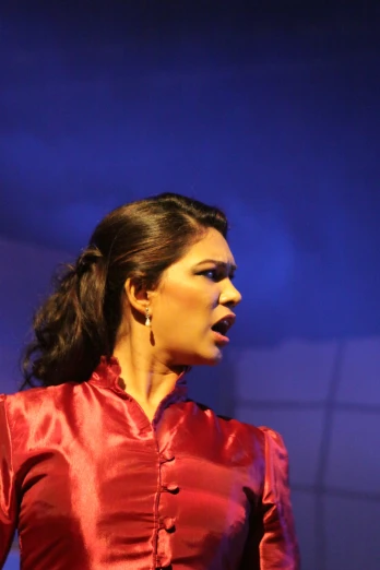 a woman in a red blouse is singing