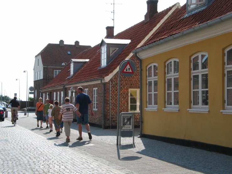 people walk by the curb in a small village