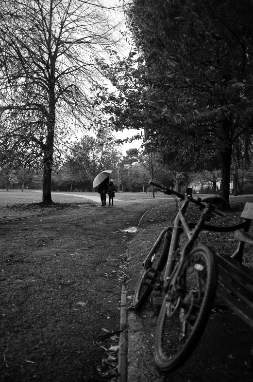 a bicycle is parked in the grass by a tree