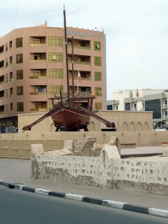 a boat on display in a city with buildings in the background