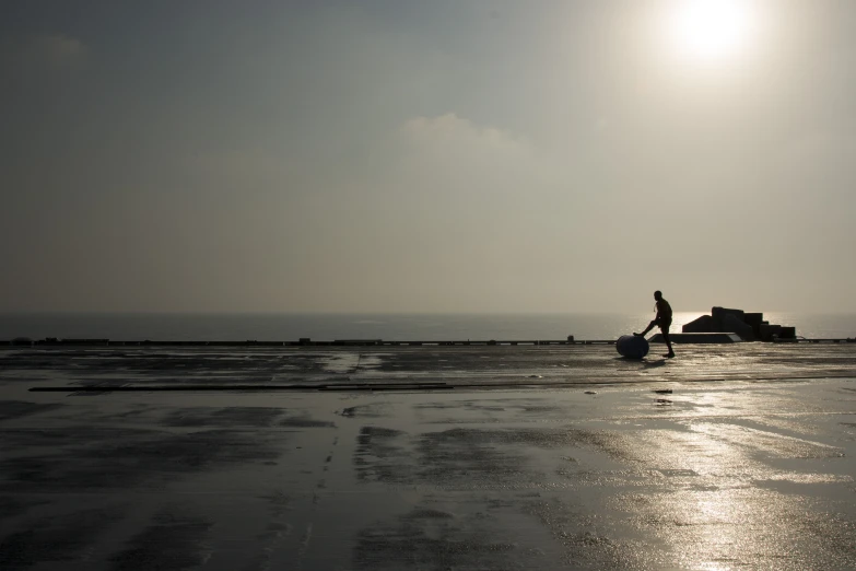 the person walks across the beach with his surfboard