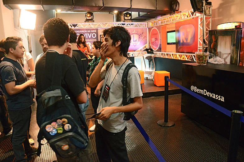 group of people stand together in front of tvs and other electronics