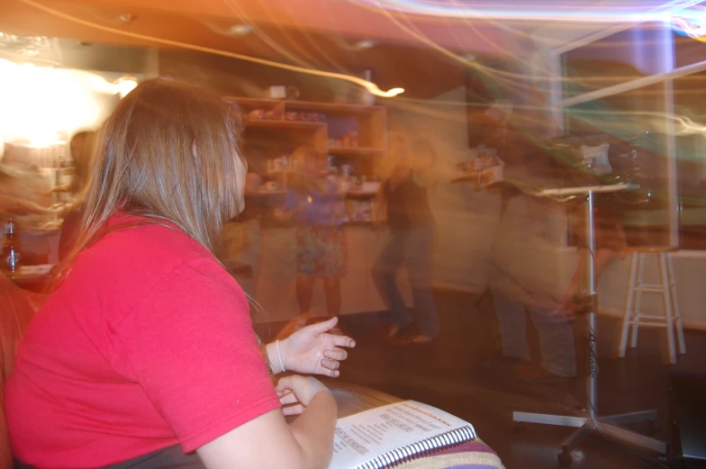 a lady in red shirt sitting down while a man plays piano