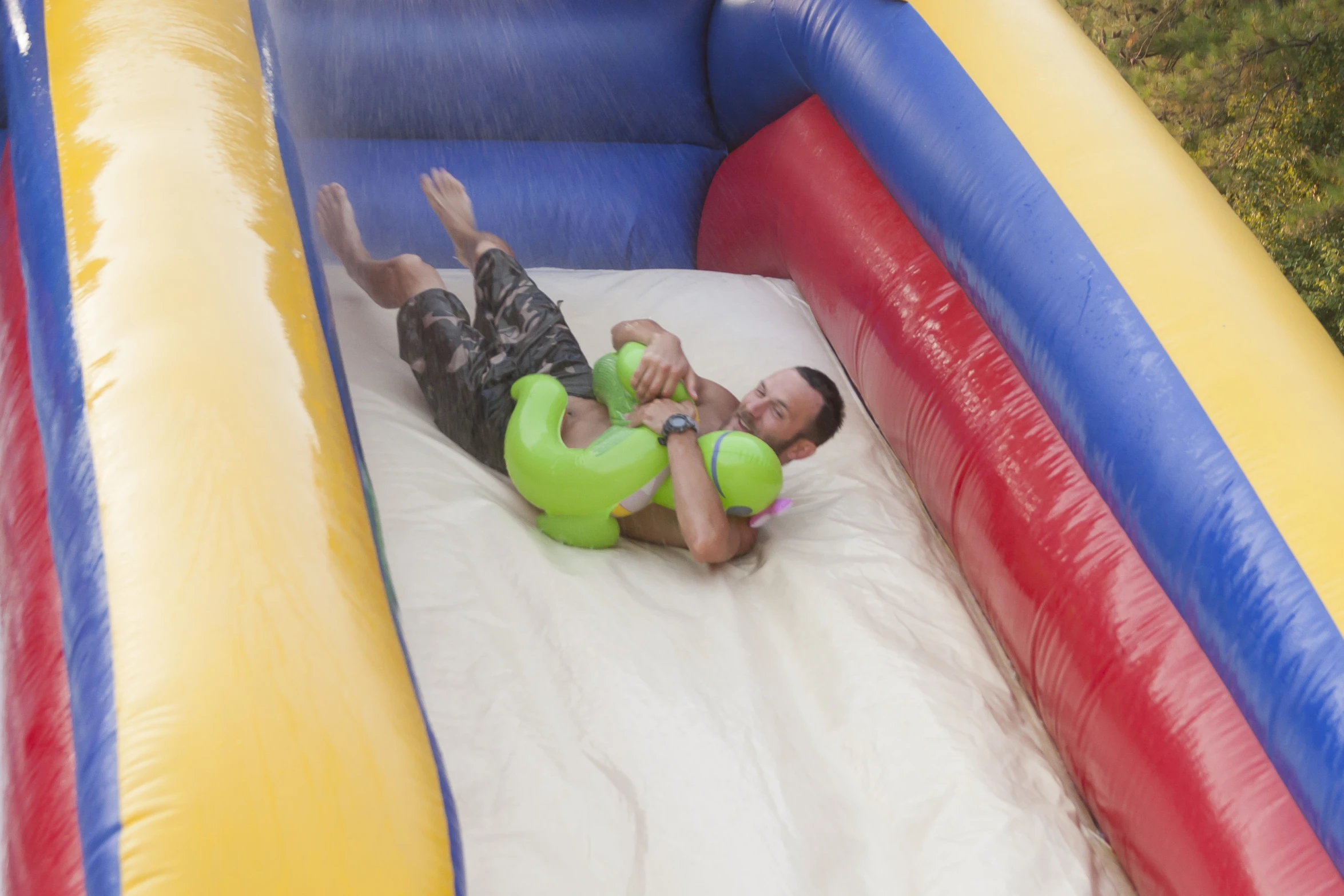 a man on an inflatable device falls from a ladder