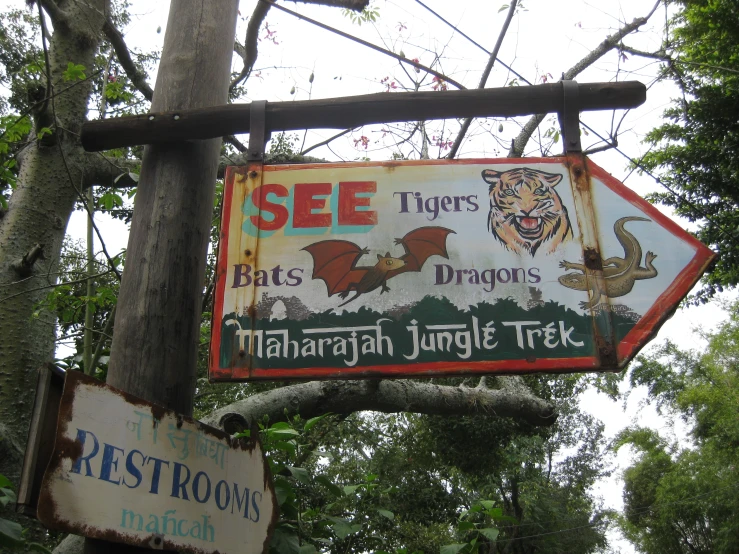 a sign for a tiger park with two signs in front of it
