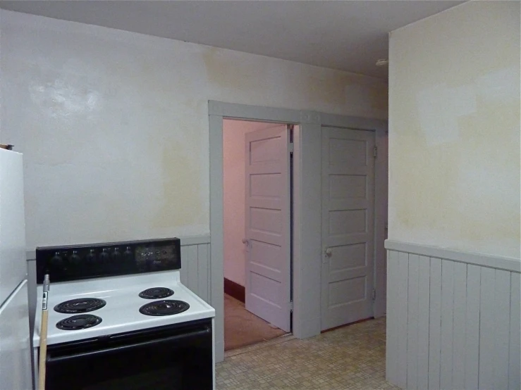 an empty kitchen is shown with the door open