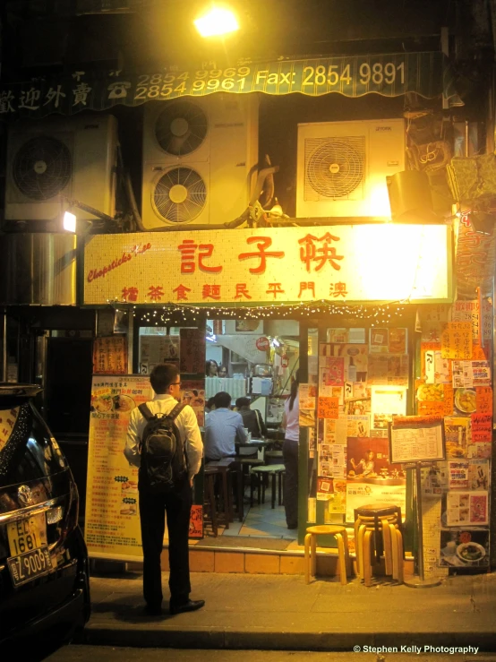 the man stands at the entrance of the restaurant