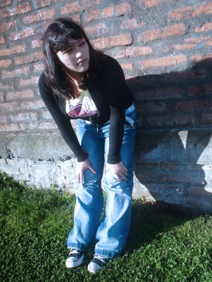 a person leaning against a wall in some grass
