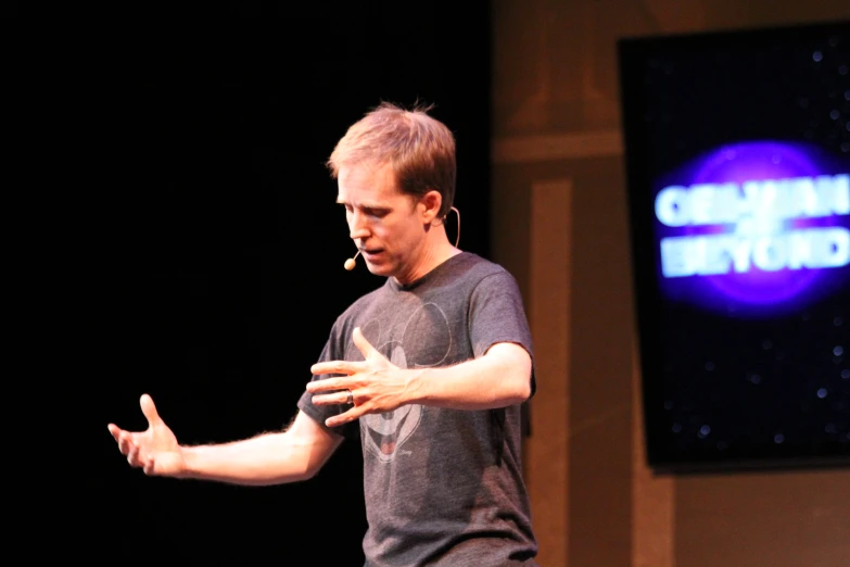 a man giving a presentation on stage during a conference