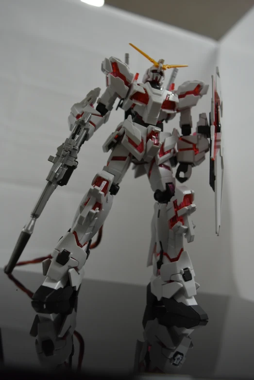 an unfinished plastic robot with weapons around the neck