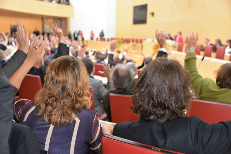 people watching an event and raising their hands up