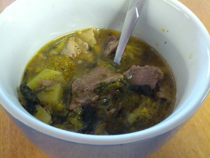 a bowl of soup on a table with a spoon in it