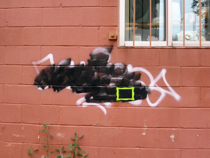 a brick wall that has a graffitti on it