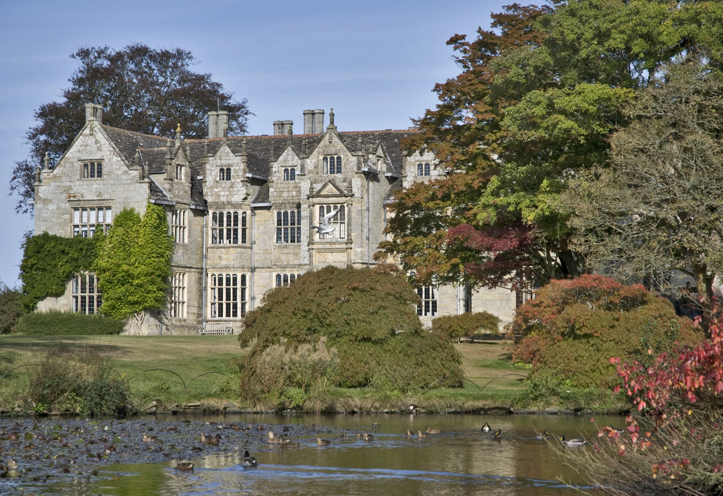 an old mansion that sits on a green grassy field