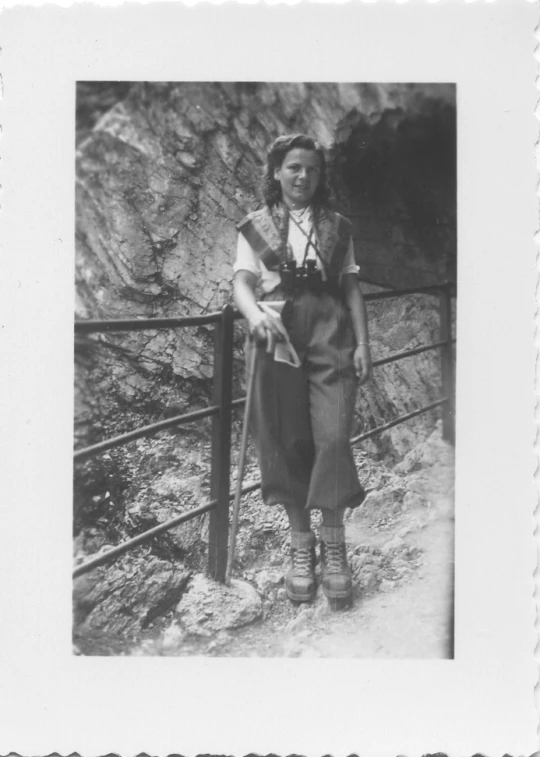 a woman wearing a apron and boots next to a rail