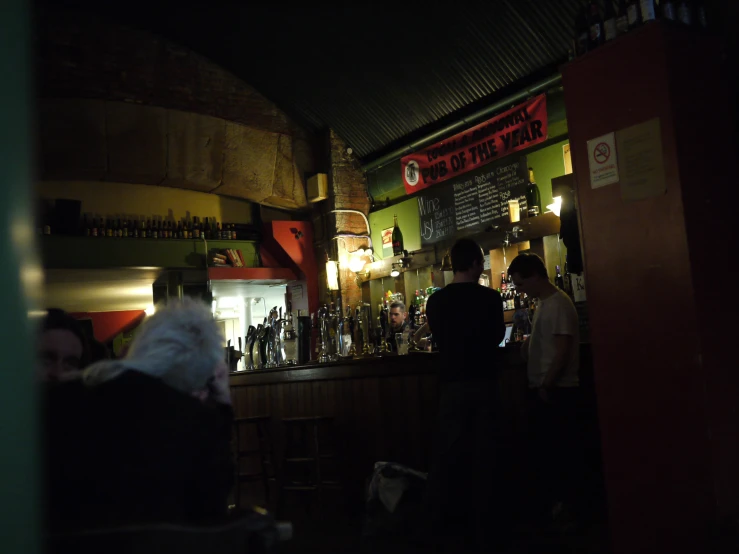 a group of people at a bar with bottles