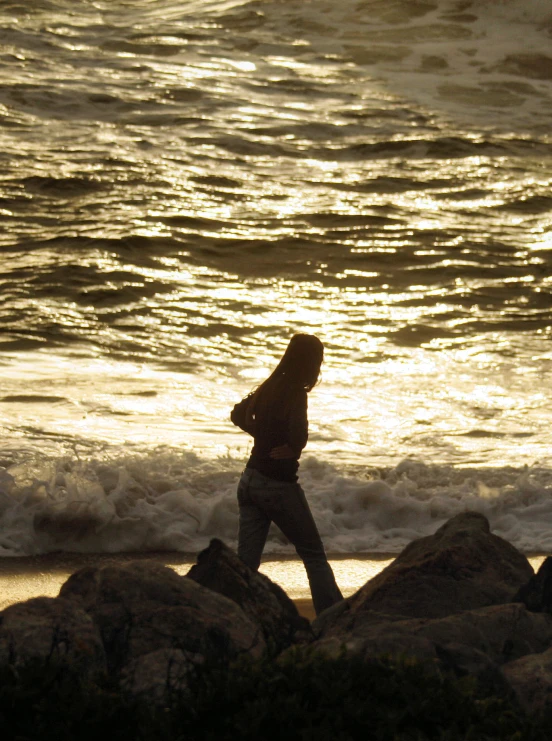 a woman on a beach holding onto a kite