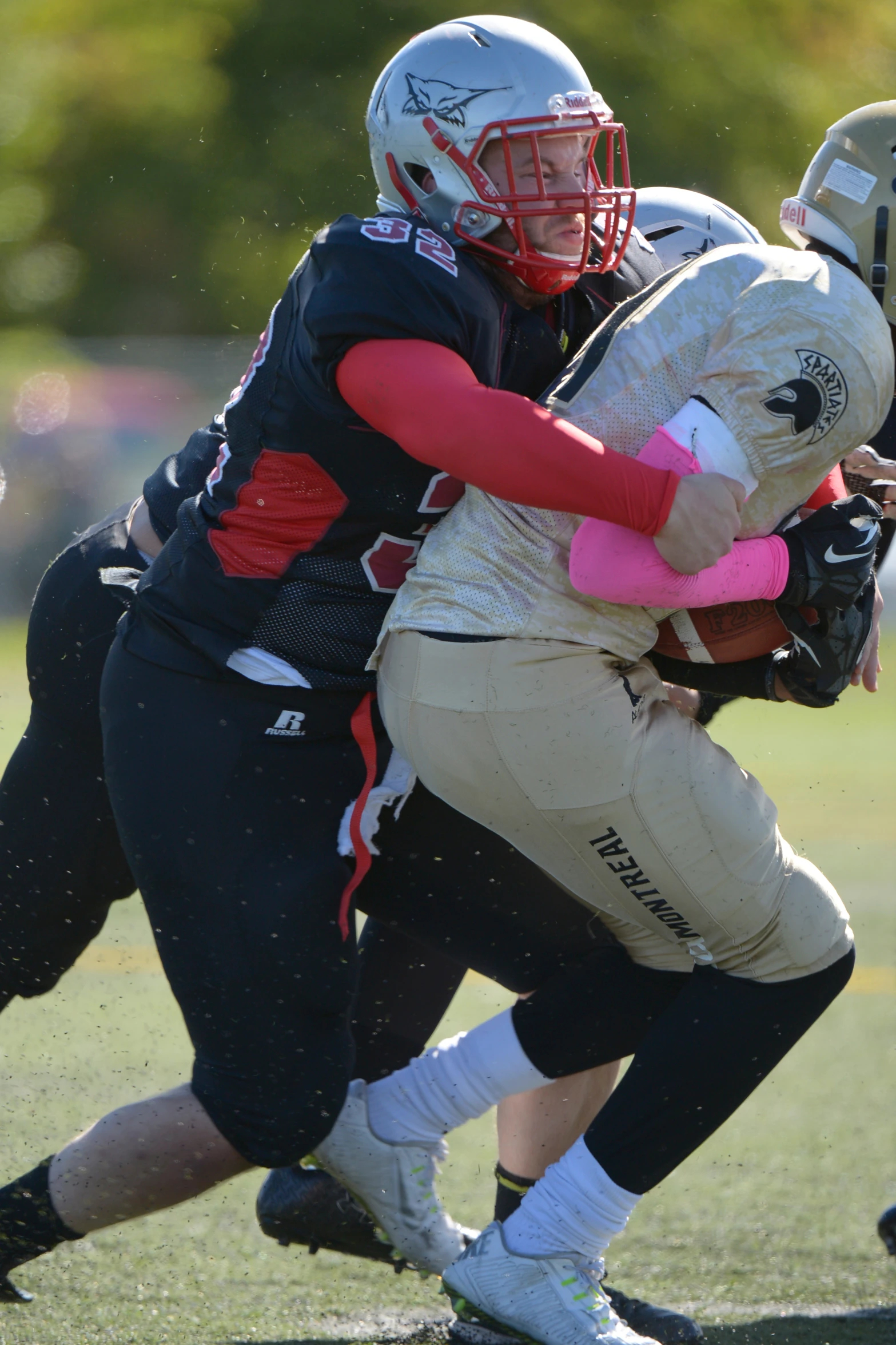 two people with helmets and a football in a game