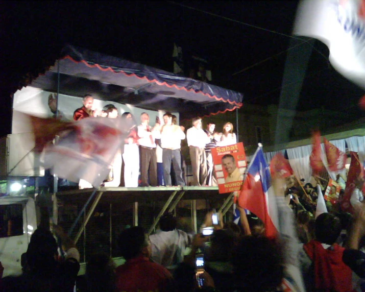 people celeting in front of a crowd on stage with cell phones