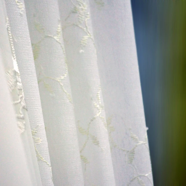 white curtains with green leaves hanging from the rod