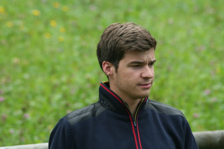 a young man in the middle of a field with flowers