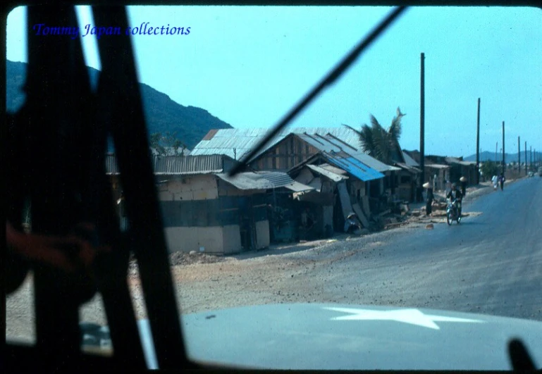 this is a view out a vehicle window of a slum roof village