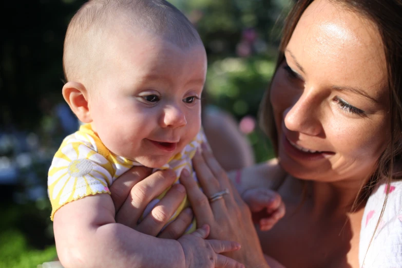 a woman holding and pointing towards her baby