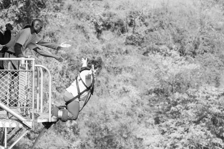 black and white image of some people on a rope