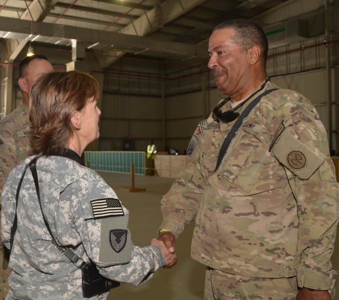 a military couple shaking hands in an air force hangar