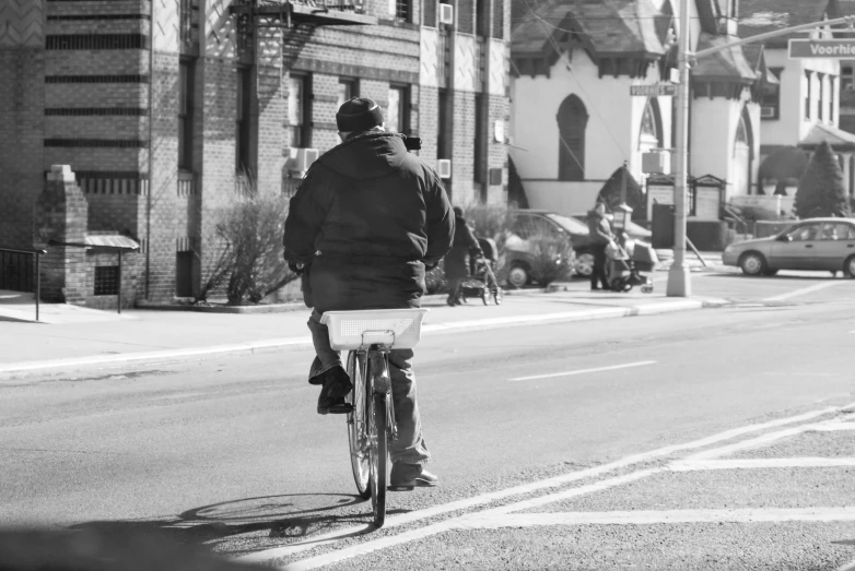 a black and white image of a man riding his bike