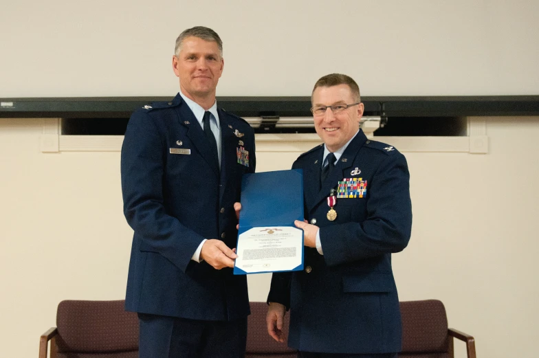 a man in a suit is presenting a document to another man