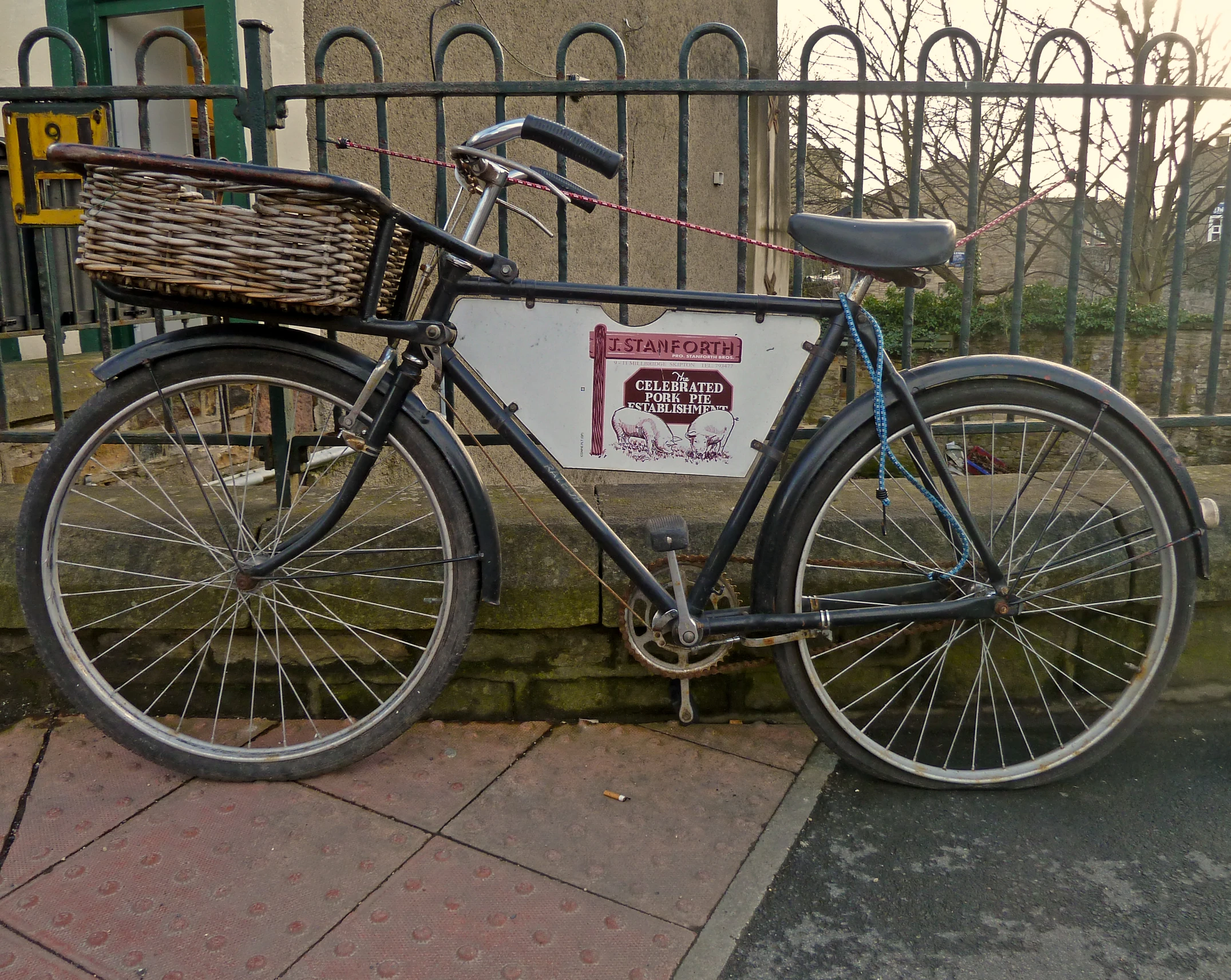 a bicycle parked in front of a metal fence