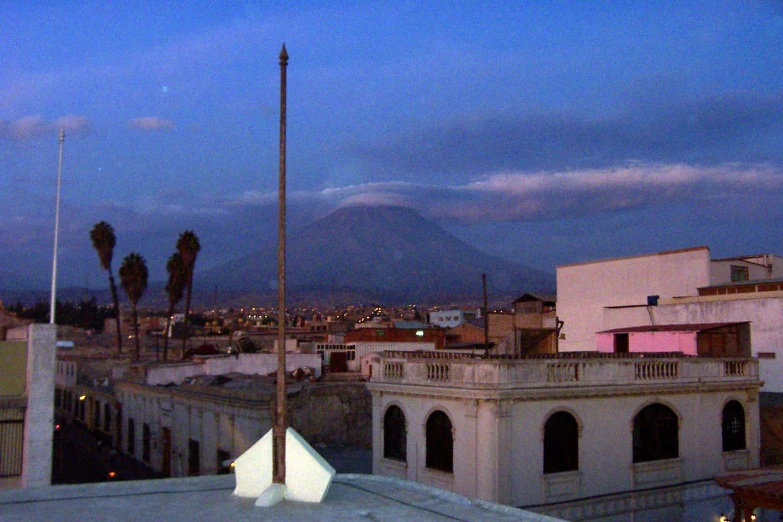 a view from the rooftop of buildings with mountains in the background