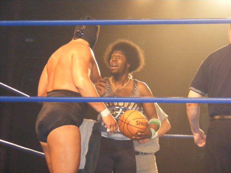 two young people holding a basketball while standing on a stage