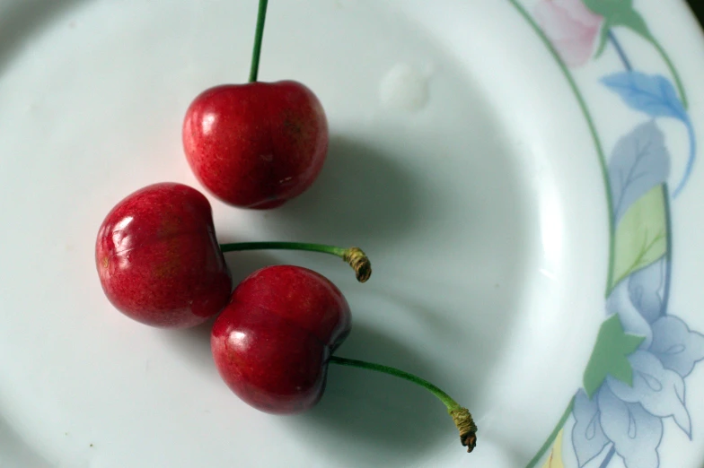 a plate with two cherries on it