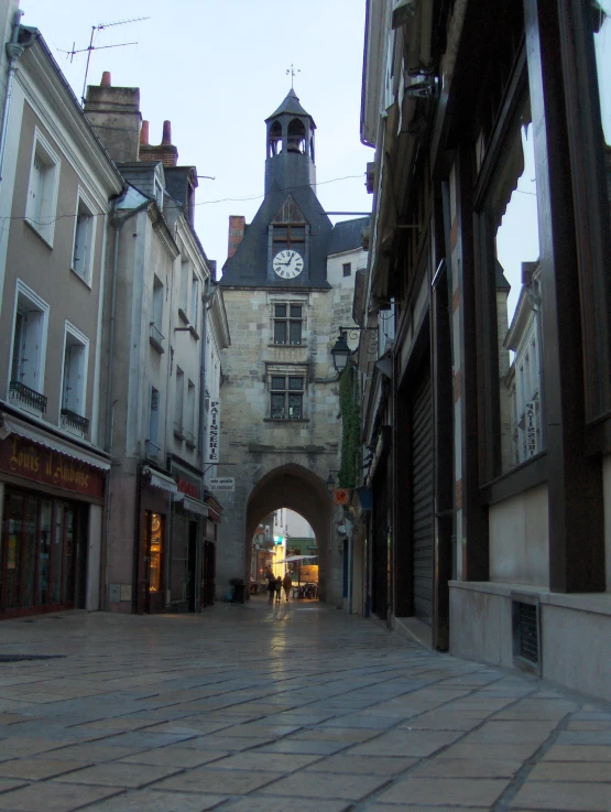 people walking down the street in front of a clock tower