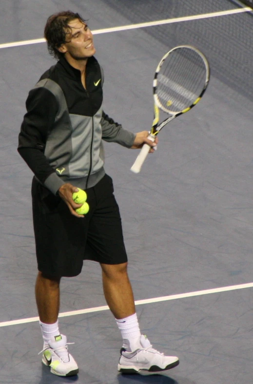 tennis player with racket and two balls on a court