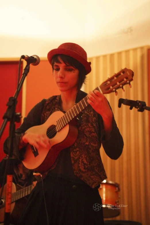 a woman playing a guitar on top of a stage