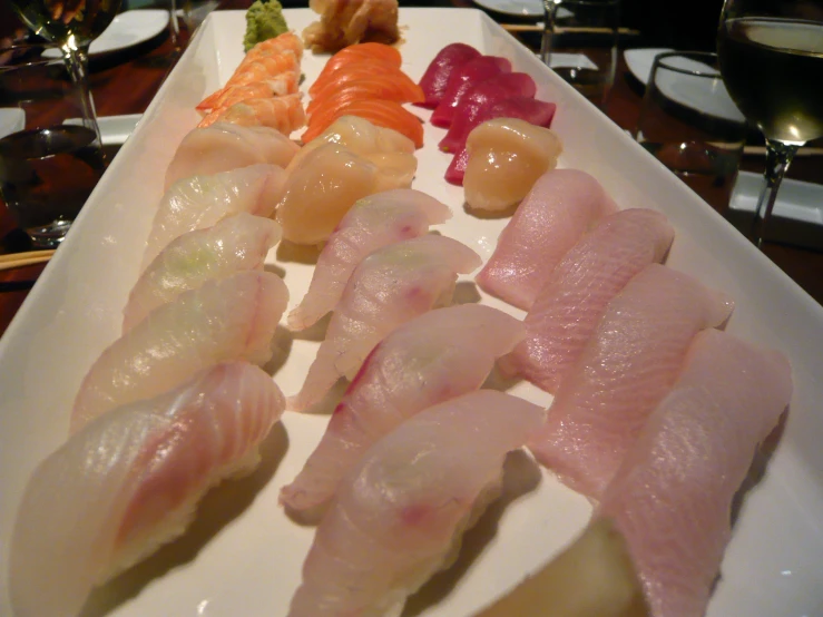 some sushi is laying out on a long white platter