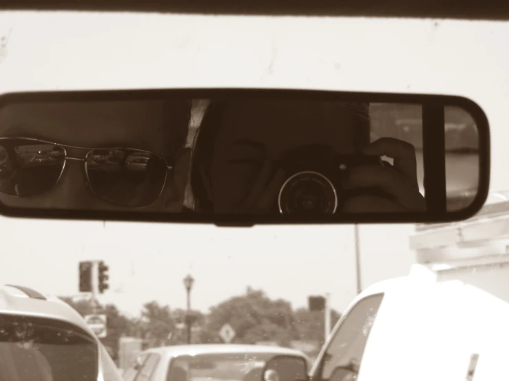 three glasses are reflected in a rear view mirror