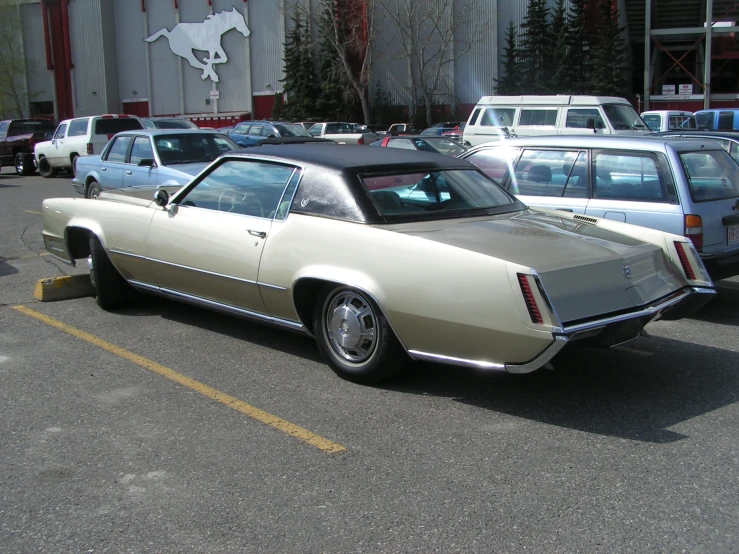 an old car in a parking lot filled with old cars