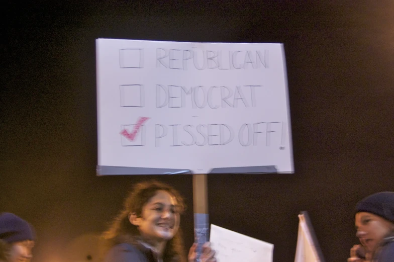 a group of people holding a sign at night