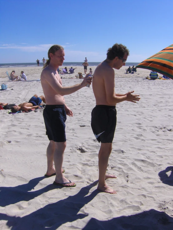 the man is pointing to another on the beach