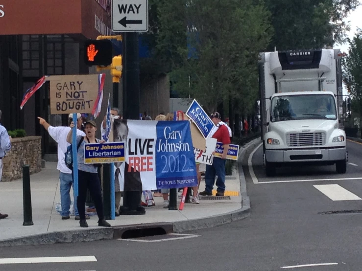 people holding signs in the street by a traffic light