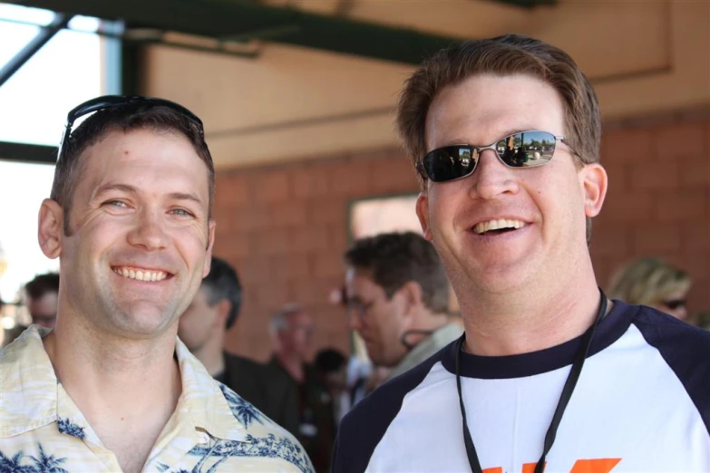 two men in shades smiling at the camera