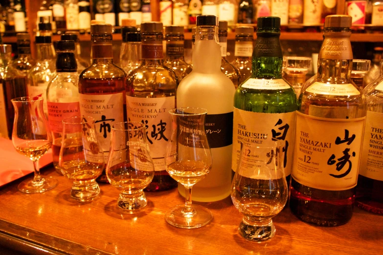 a group of bottles and glasses sit on a bar