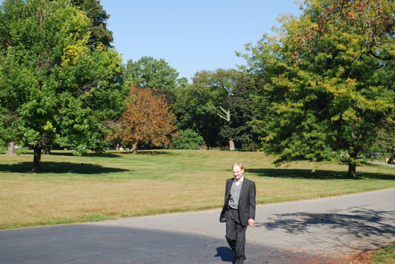 the man in a suit is walking down the road